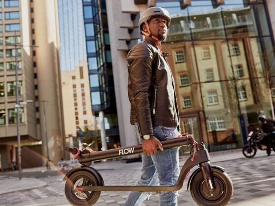 Man carry Flow Electric Scooters in city