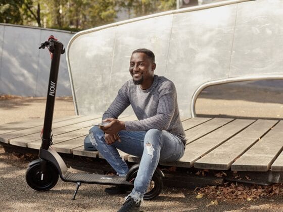 Man sitting by Greenwich Flow Electric Scooters