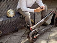 Man sitting on bench with Flow Electric Scooters